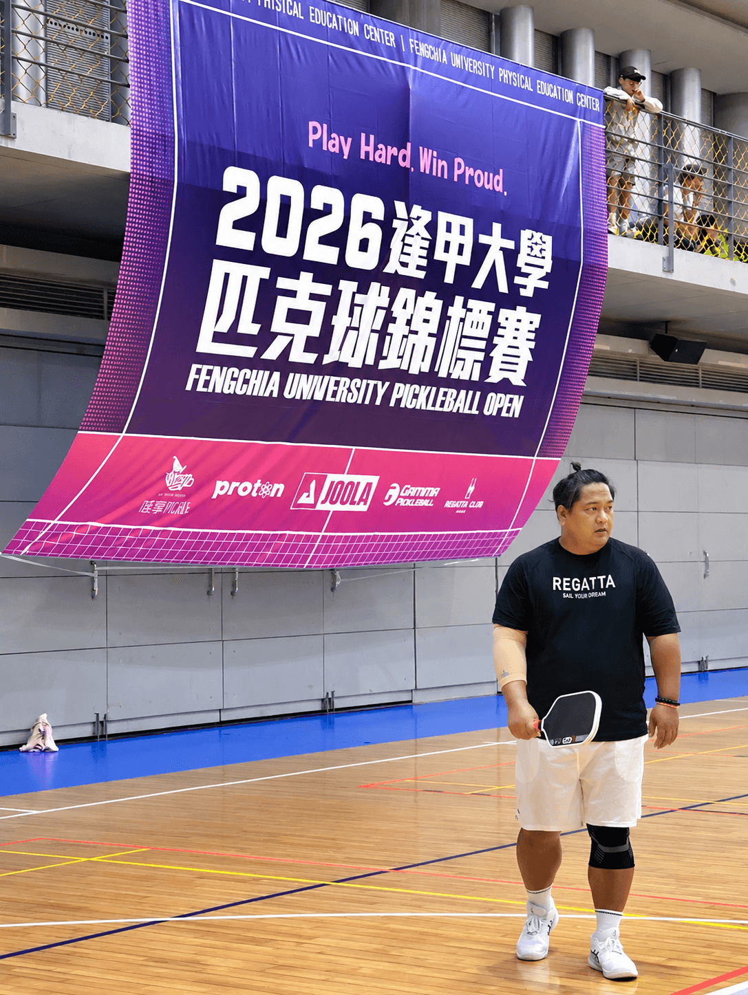 小黑教練於匹克球賽事場館持拍站立